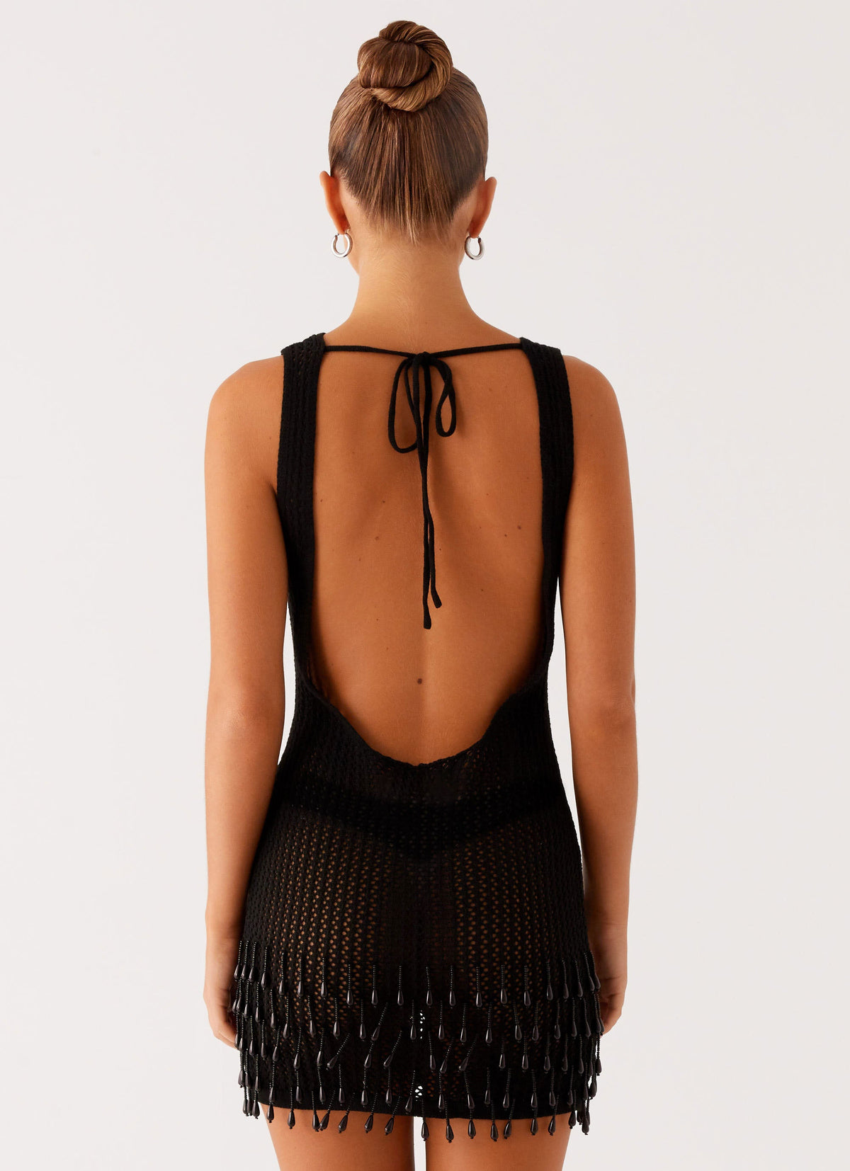 Women's black crochet mini dress with open back and beaded fringe hem