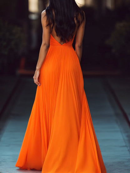 Women's orange pleated halter maxi dress with deep V-neckline and floor-length skirt