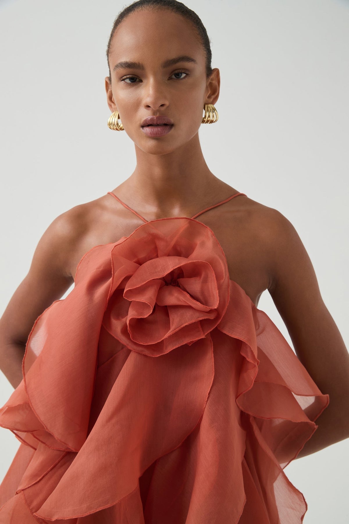Women's coral sleeveless halter maxi dress with layered ruffles and front flower detail