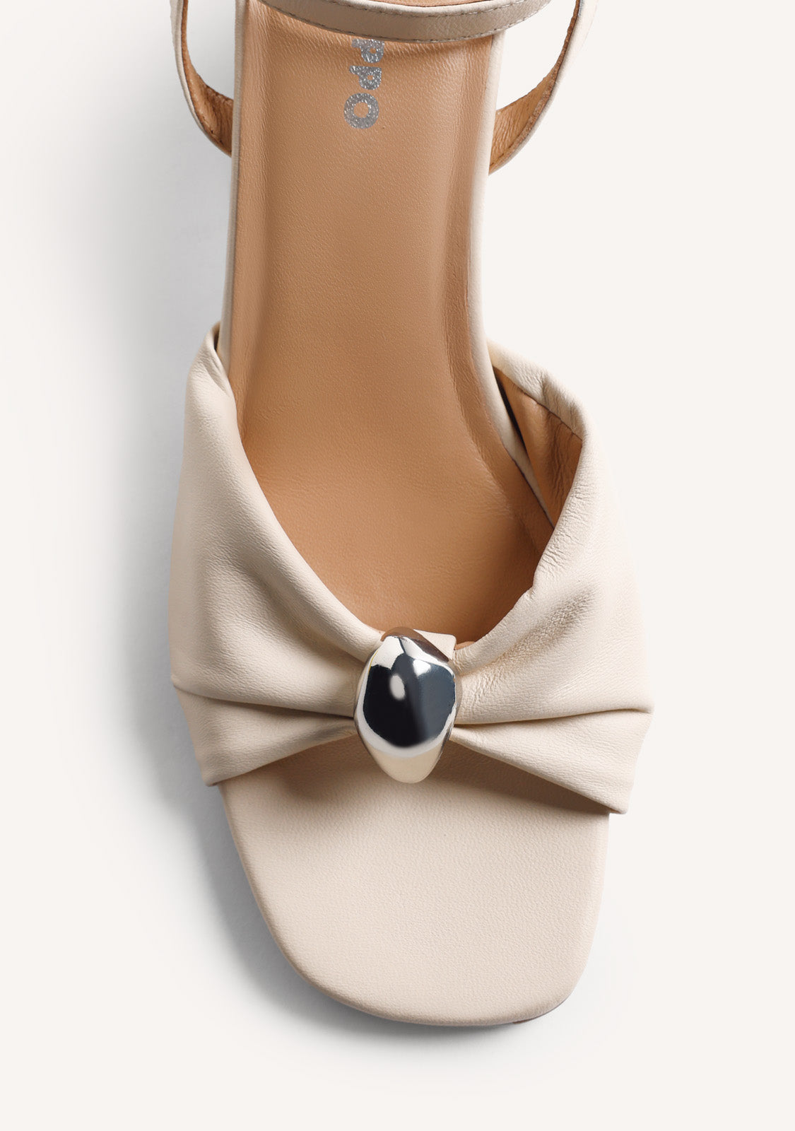 Beige women's heeled sandals with bow detail, silver-tone ornament and ankle buckle strap