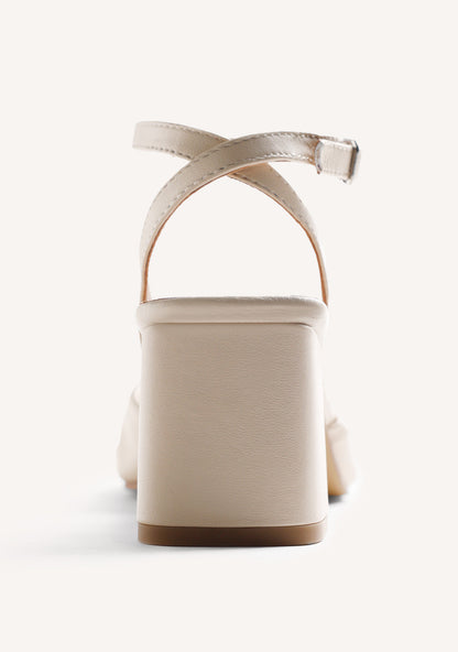 Beige women's heeled sandals with bow detail, silver-tone ornament and ankle buckle strap