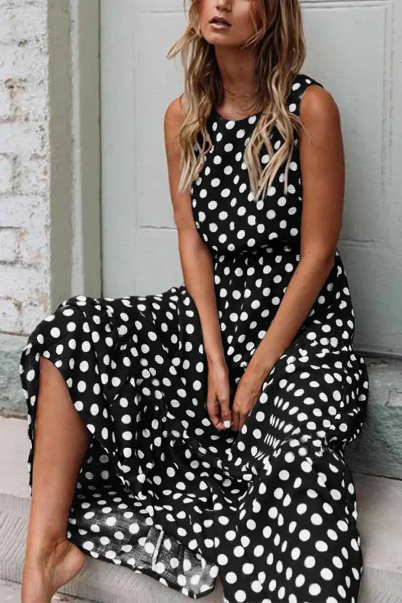 Women's sleeveless polka dot midi dress with a round neckline and flowing skirt