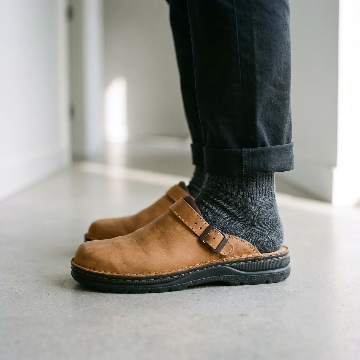 Men's closed-toe mule shoes with buckle straps and raised black soles