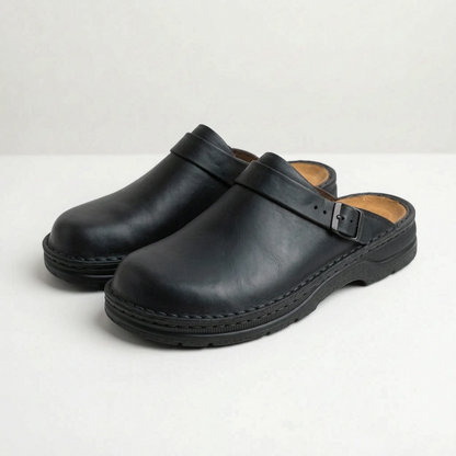 Men's closed-toe mule shoes with buckle straps and raised black soles