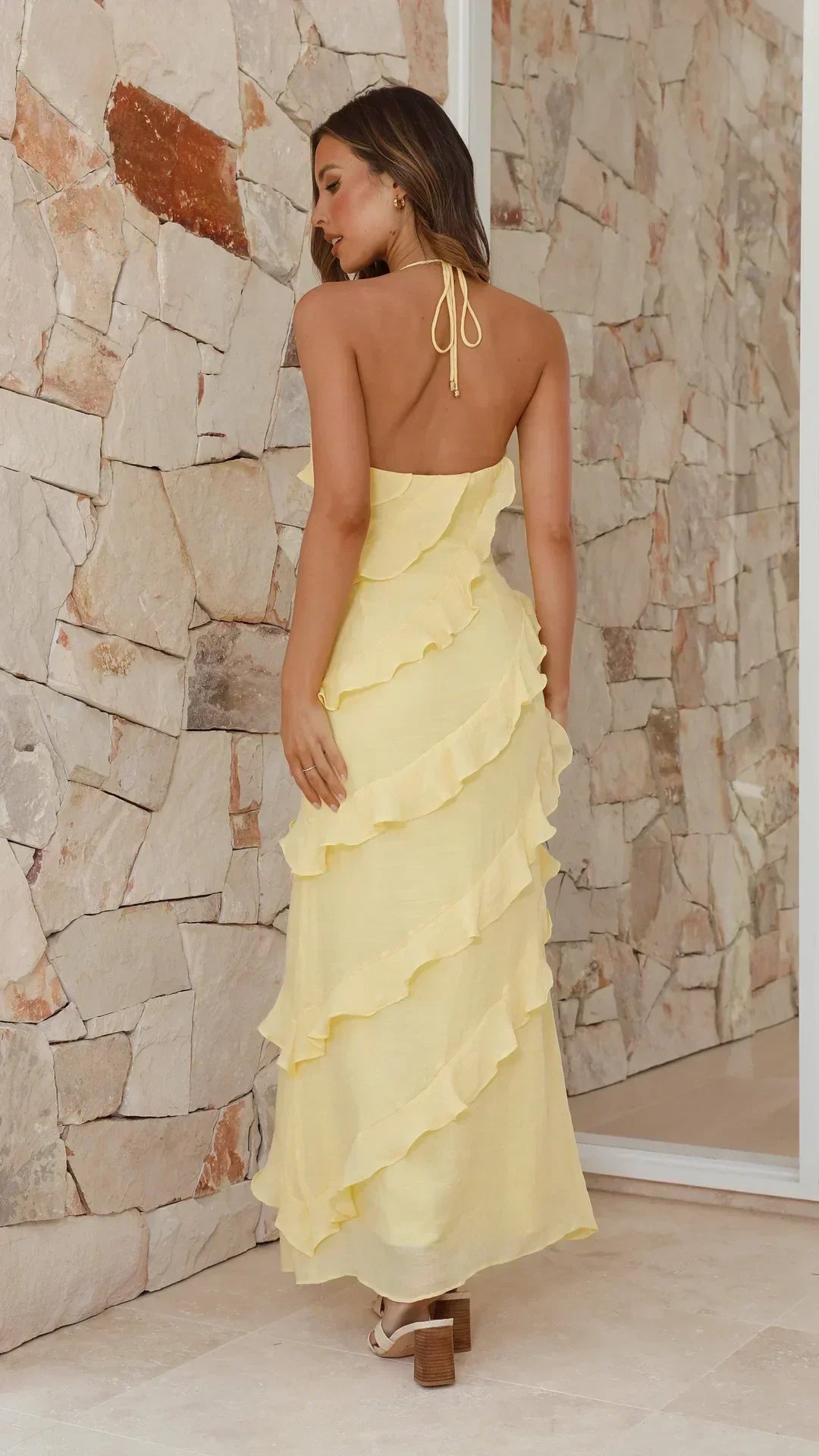Women's yellow halter maxi dress with layered ruffles and open back