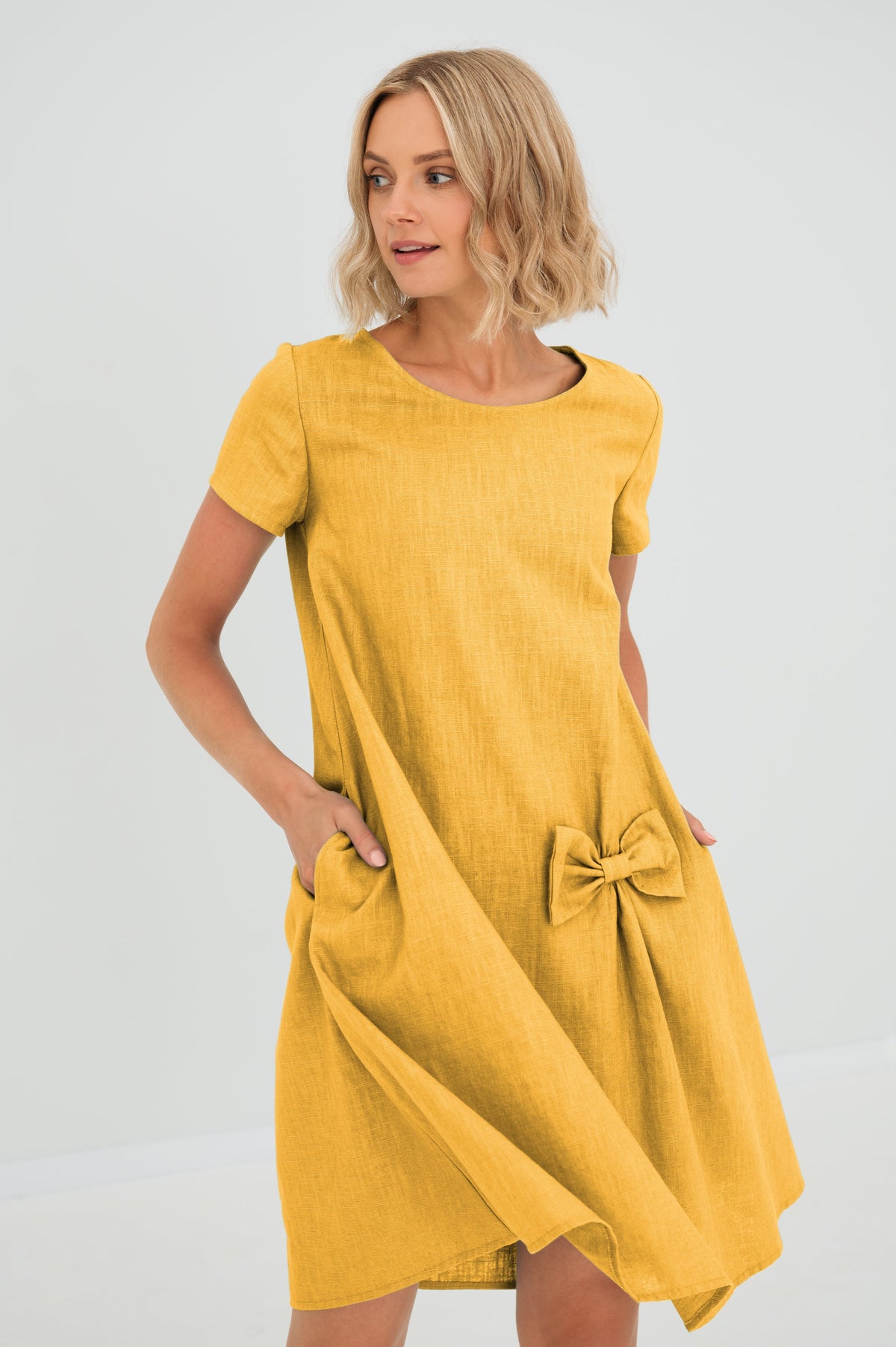 Women's A-line short dress with round neckline, short sleeves, bow detail and front pockets