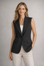 Women's sleeveless notched lapel blazer with button fastening and flap pockets
