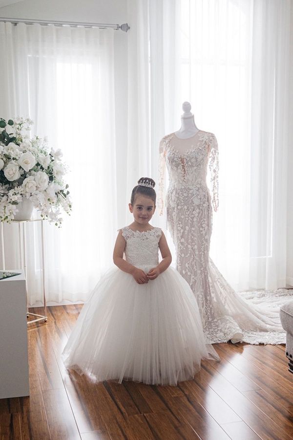 Ivory girls' lace ball gown dress with full tulle skirt, bow back and floral hem