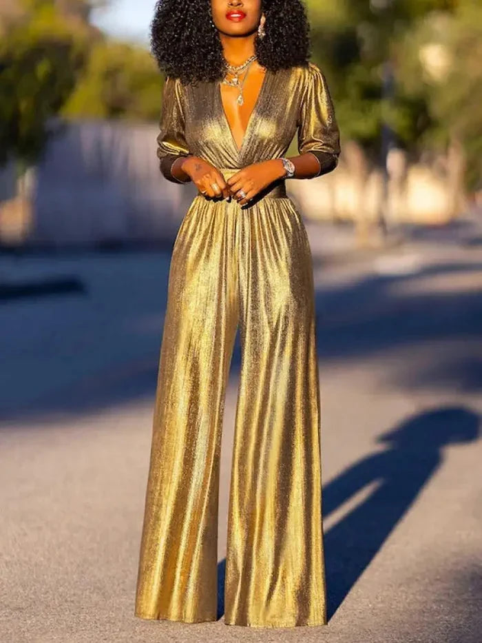 Woman wearing a shiny wide-leg jumpsuit with a deep V-neckline and three-quarter sleeves