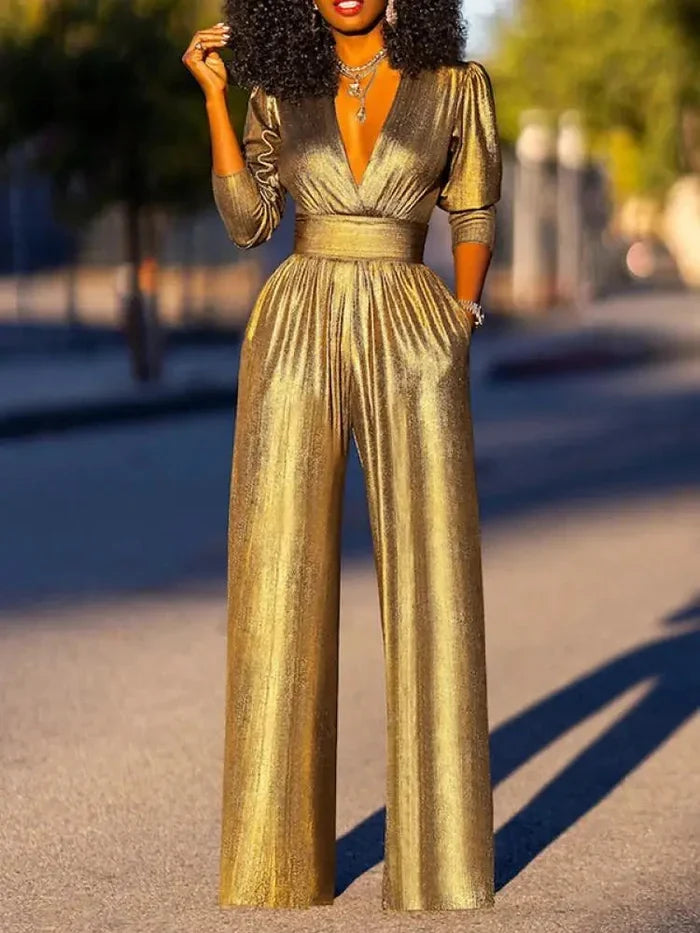 Woman wearing a shiny wide-leg jumpsuit with a deep V-neckline and three-quarter sleeves