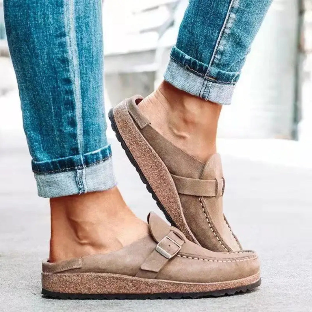 Women's mule sandals with round toes, side buckles and flat layered soles
